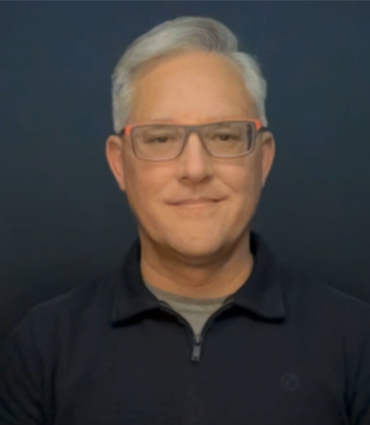 Professional headshot of David Evans, a man with gray hair and glasses, looking directly at the camera with a slight smile.