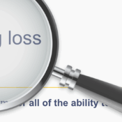 A close-up image shows a magnifying glass over the words "hearing loss" on what appears to be a dictionary or website definition. The text "hearing loss" is displayed in a large, bold, sans-serif font. Below it, in a smaller font, are the phonetic transcriptions: "noun [ U ]" and "us /ˈhirɪŋ ˌlɔːs/". Partially visible below the magnified area, in a smaller, lighter font, is the beginning of a sentence: "the _____ of som____ all of the ability t____". The background is white.