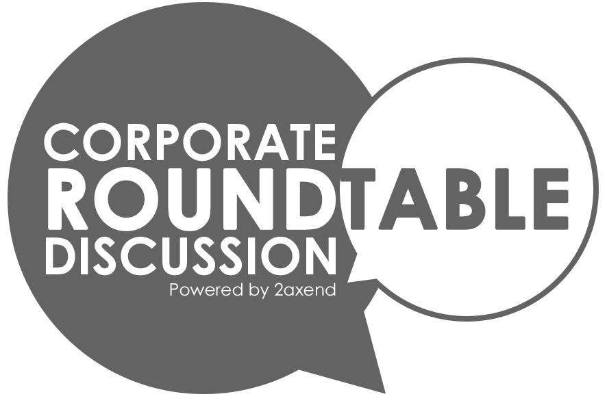 A logo for "Corporate Roundtable Discussion Powered by 2axend." The design features two overlapping speech bubbles; a large grey bubble on the left contains the white text "CORPORATE" and "DISCUSSION," while a smaller white bubble on the right contains the grey text "ROUNDTABLE." The tagline "Powered by 2axend" appears in small white font at the bottom of the larger grey bubble.